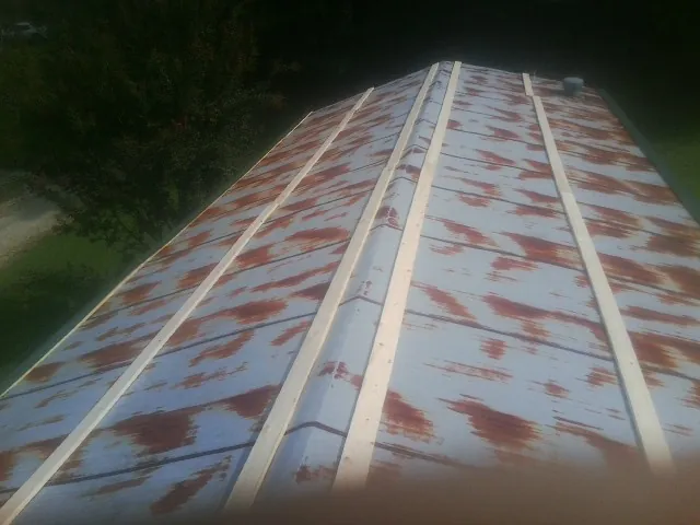 Rusted metal roof panels with new wood purlins before replacement — Storm Damage Roof Repair in Olivehill by Roofing Brothers