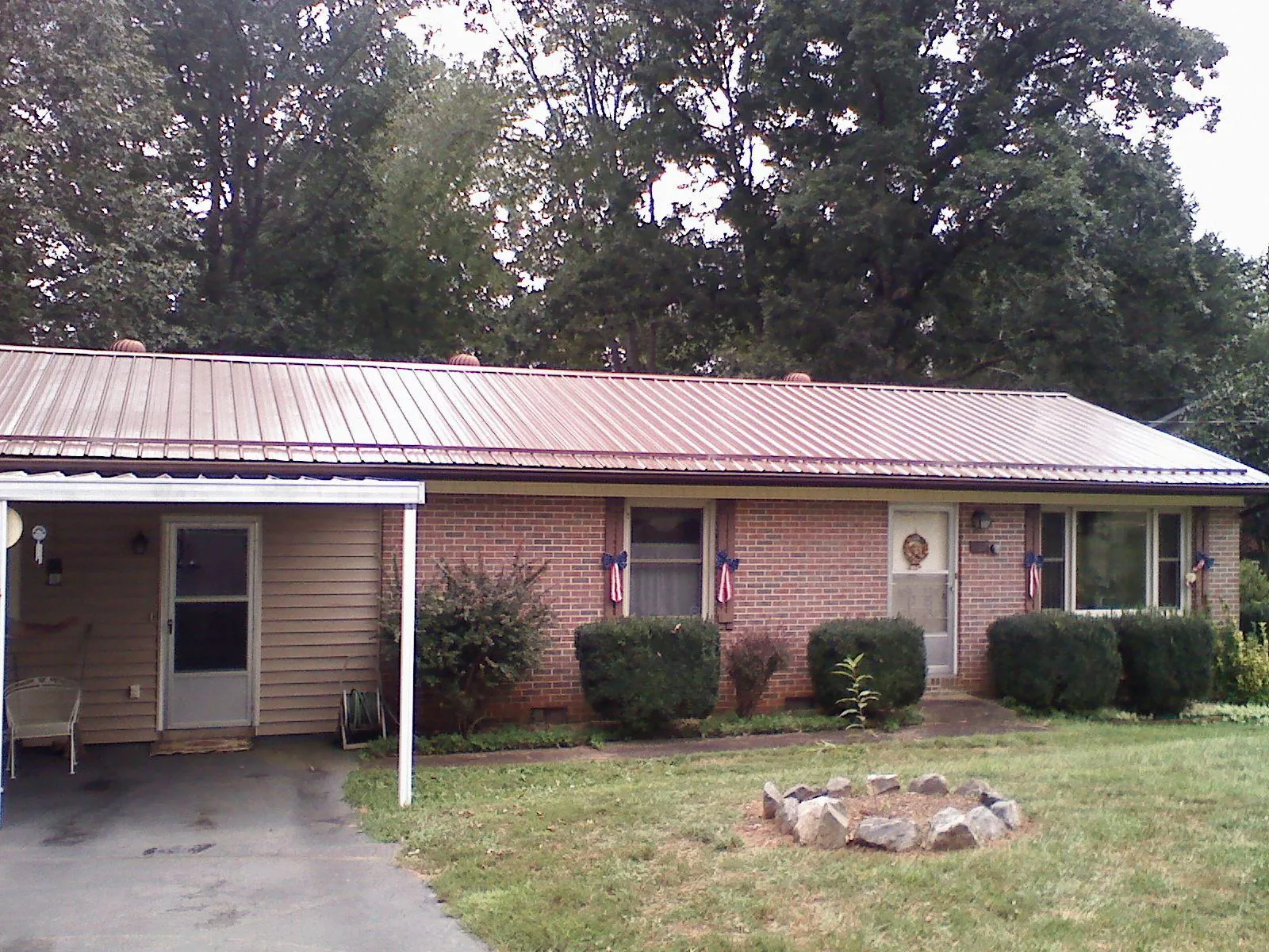 Bronze metal roof and carport on a brick ranch home — Roof Repair work by our crew in Olivehill